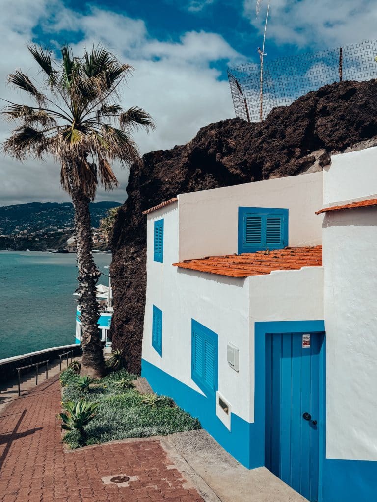 A white-and-blue cottage on the seafront promenade in Funchal