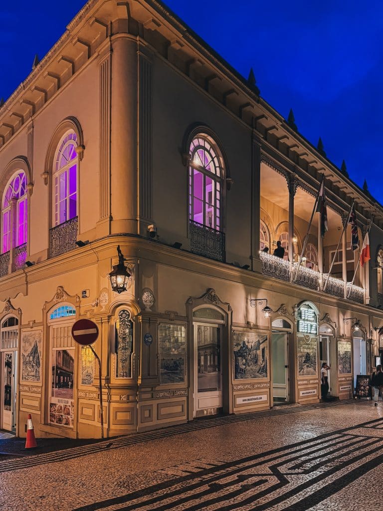 A historic arcaded building in central Funchal at dusk
