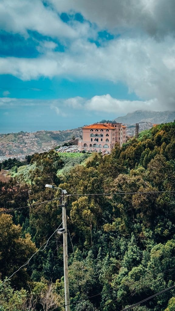The former Monte Palace hotel building (the interior is not open to visitors) seen from the garden, with a panorama of the hills of Funchal behind. Photo: Ewelina Podrez-Siama 2025