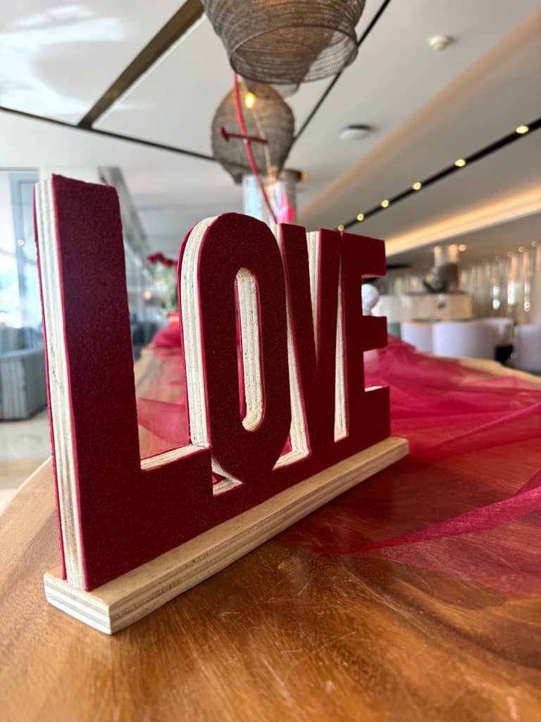 Red LOVE sign on a wooden counter in the hotel lobby