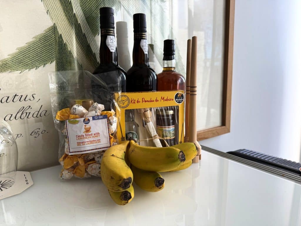 Madeira souvenirs by the window of a hotel room: bottles, bananas and sweets