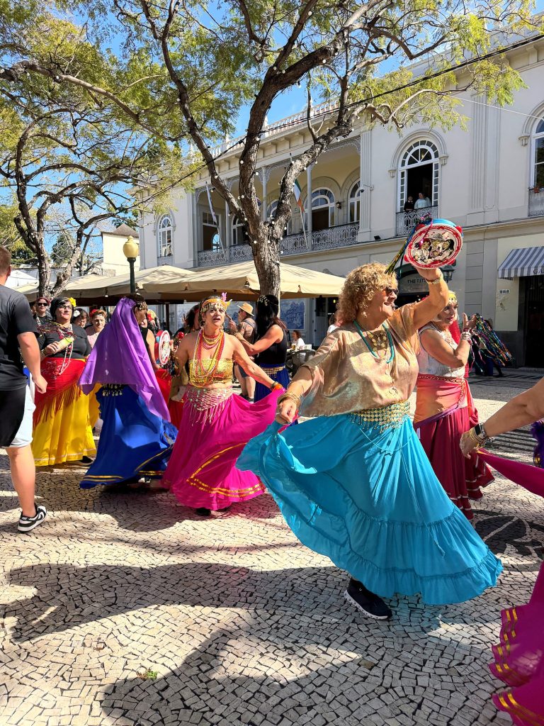 Dancers in colourful skirts during the Carnaval Solidário on Avenida Arriaga in Funchal