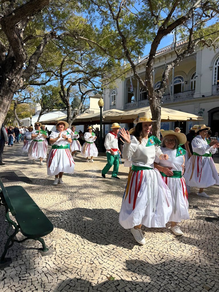 Women in a Carnival procession wearing white costumes with red and green skirts in Funchal