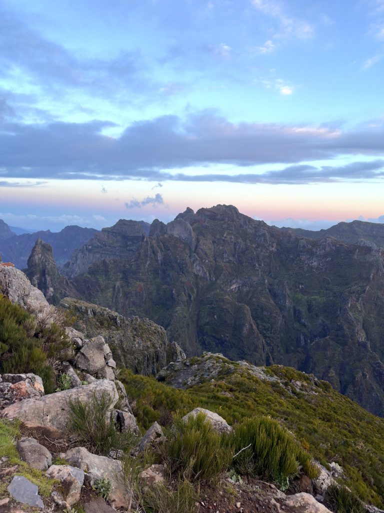 Jagged peaks in the centre of Madeira in the morning light, with rocks and shrubs in the foreground