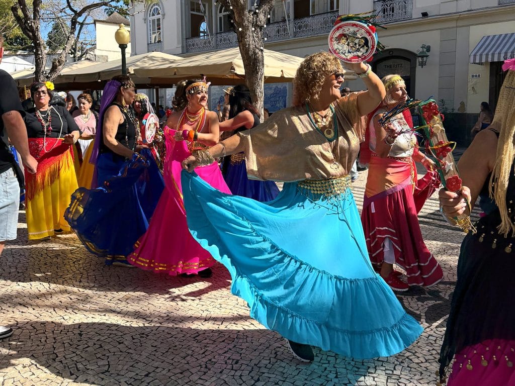 Dancers in colourful skirts whirling during the Carnaval Solidário on Avenida Arriaga in Funchal