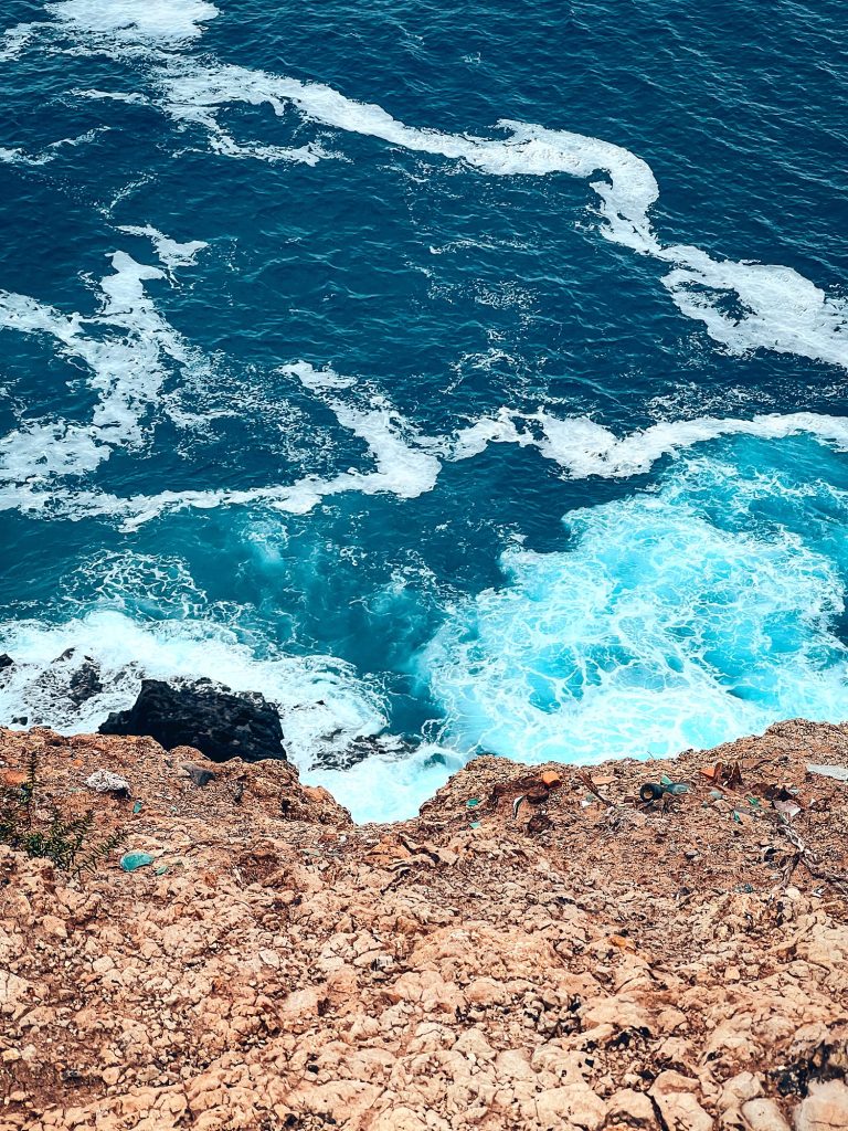 Turquoise ocean breaking on the rocks below the cliffs of Ponta de São Lourenço