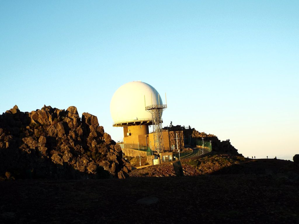 The white radar dome on the summit of Pico do Arieiro and jagged rocks lit by the morning sun