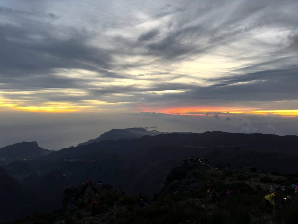 Dawn above the clouds on Pico do Arieiro, an orange band of light on the horizon