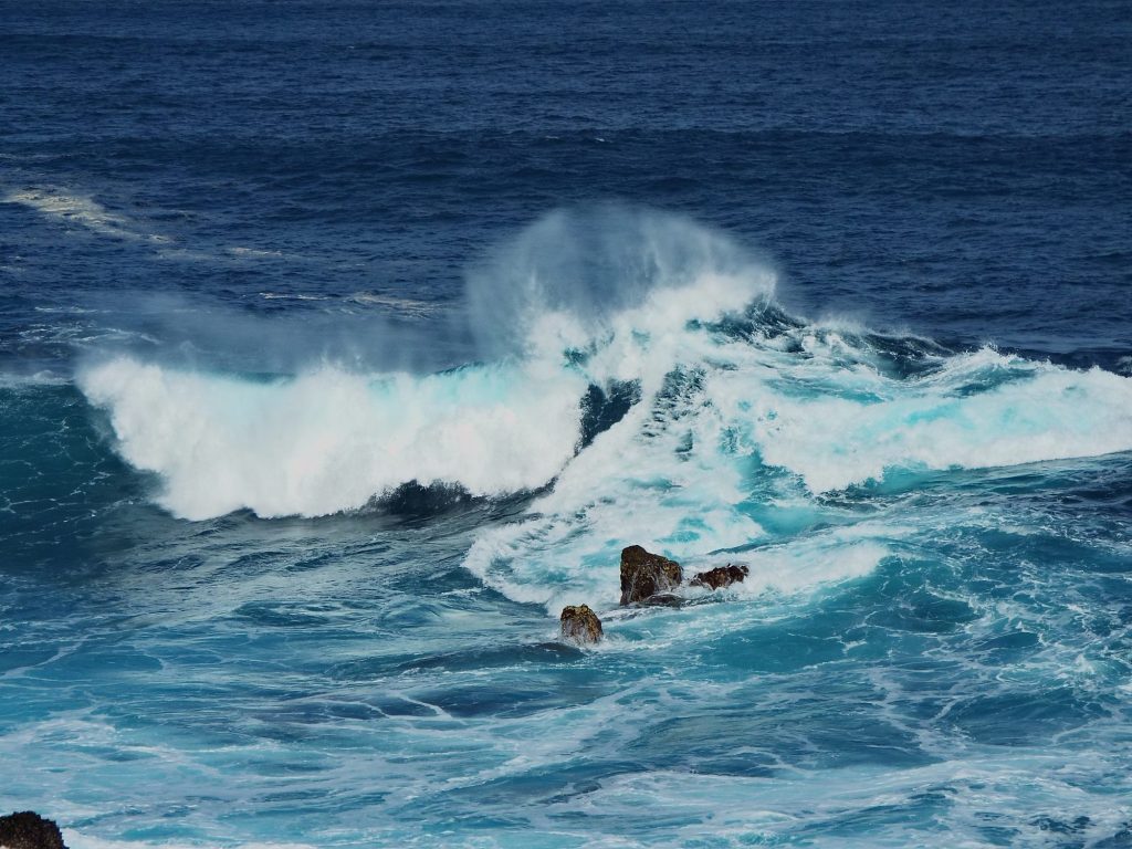 A big wave crashing on the rocks by the pools in Porto Moniz