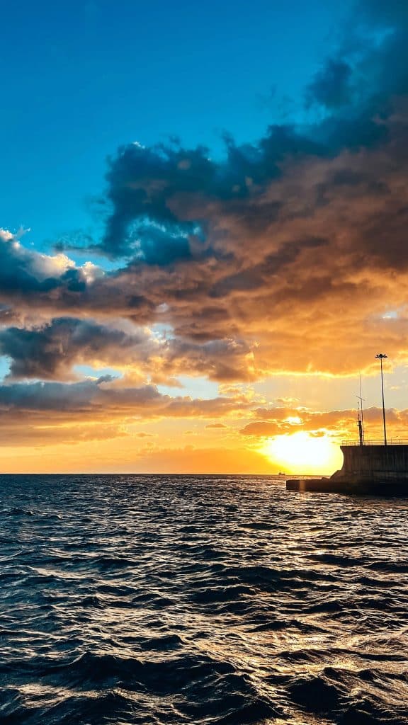 Sunset over the ocean and clouds seen from the deck on the way back to Funchal harbour