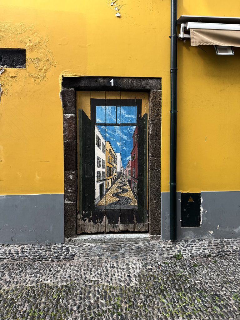 A painted door on a yellow façade in the Zona Velha, Funchal